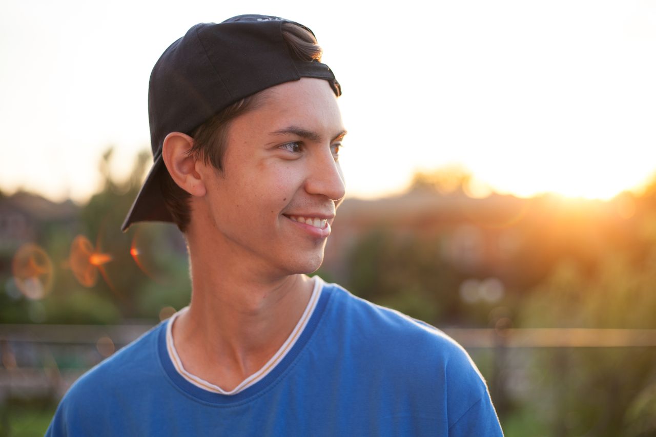 teen in black hat smiling