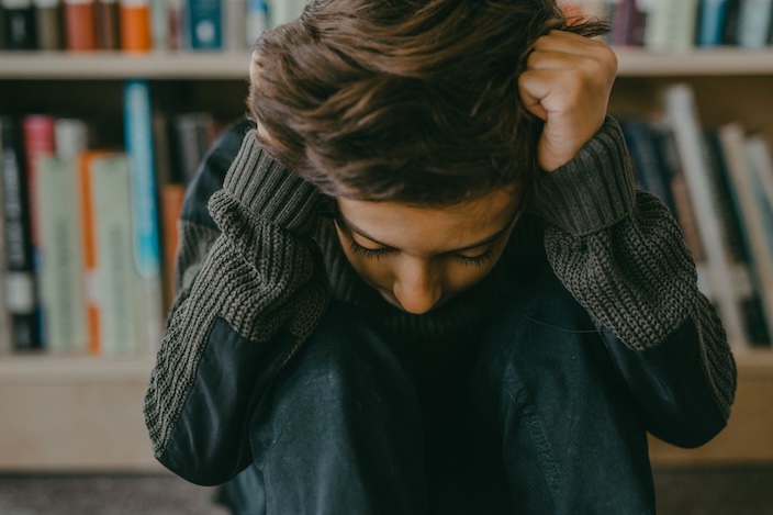 teen with head in hands