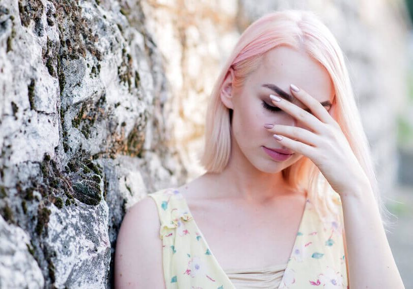 Worried teenager woman covering her face with hand, Scared woman